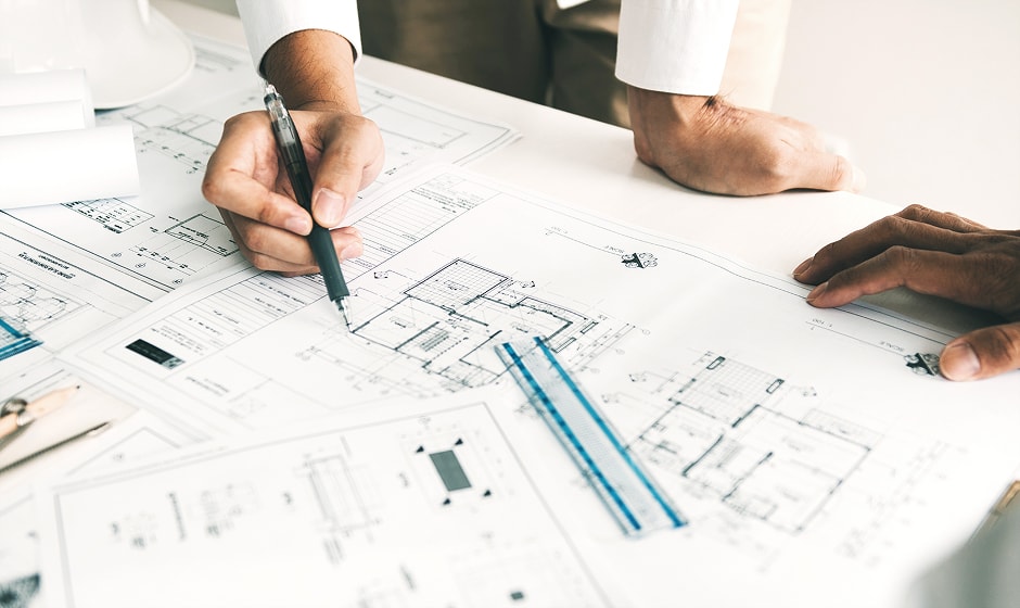 建築図面を広げて打ち合わせをする様子
